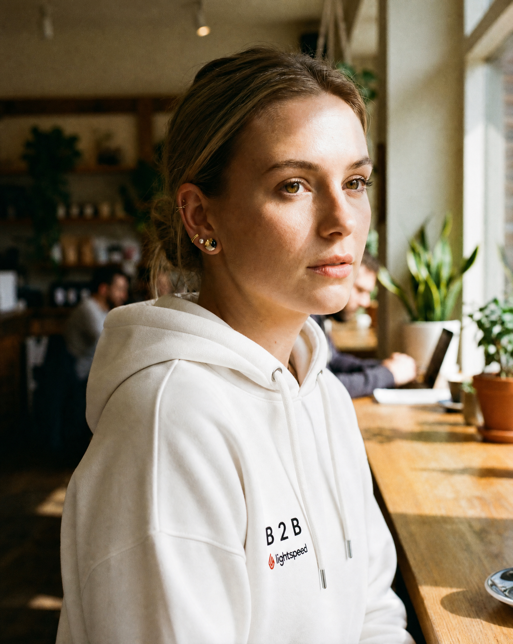 Wearing the white B2B × Lightspeed embroidered hoodie in a café