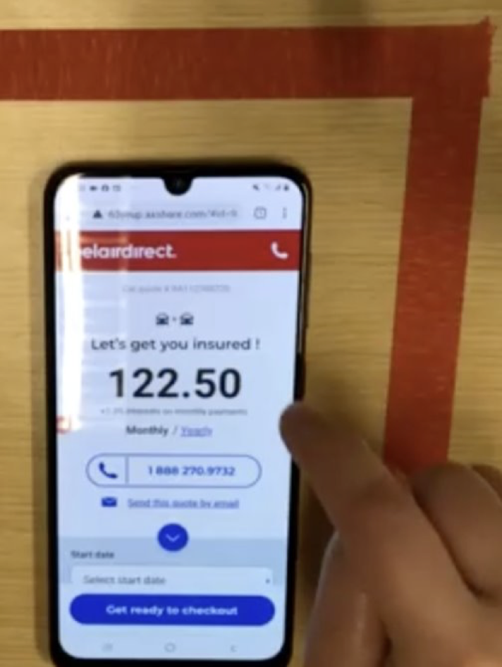 A participant's hand interacting with the belairdirect quote prototype on a phone
